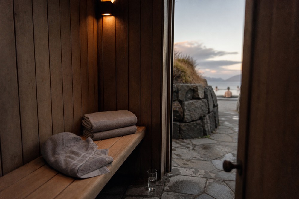 A private changing cubicle with a wooden bench, folded towels and a locked door in a spa