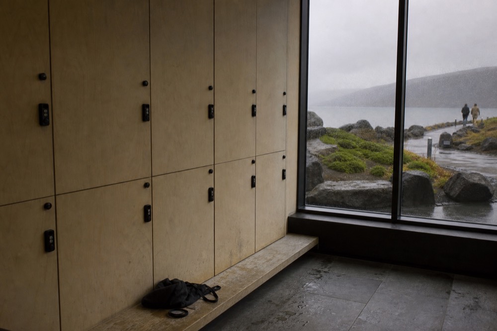 A wooden locker row with an electronic wristband resting on a bench in a spa changing room