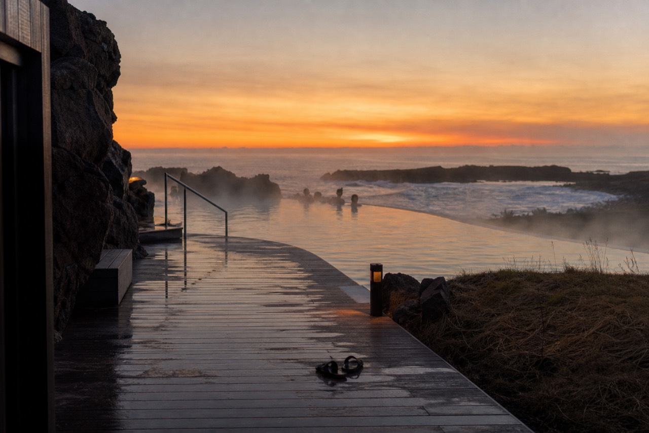 Steaming geothermal lagoon at the ocean's edge with an infinity horizon at dusk