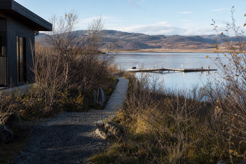 Wooden walkway leading to geothermal pools beside a lake in east Iceland