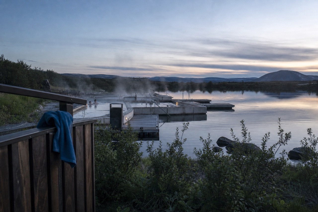 Geothermal pools floating on a still lake in east Iceland at dusk