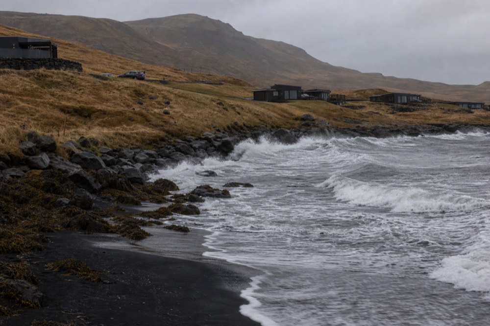 Black sand beach with large waves breaking along the shoreline