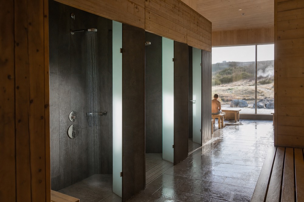 A row of shower cubicles in a bright modern bathhouse changing area