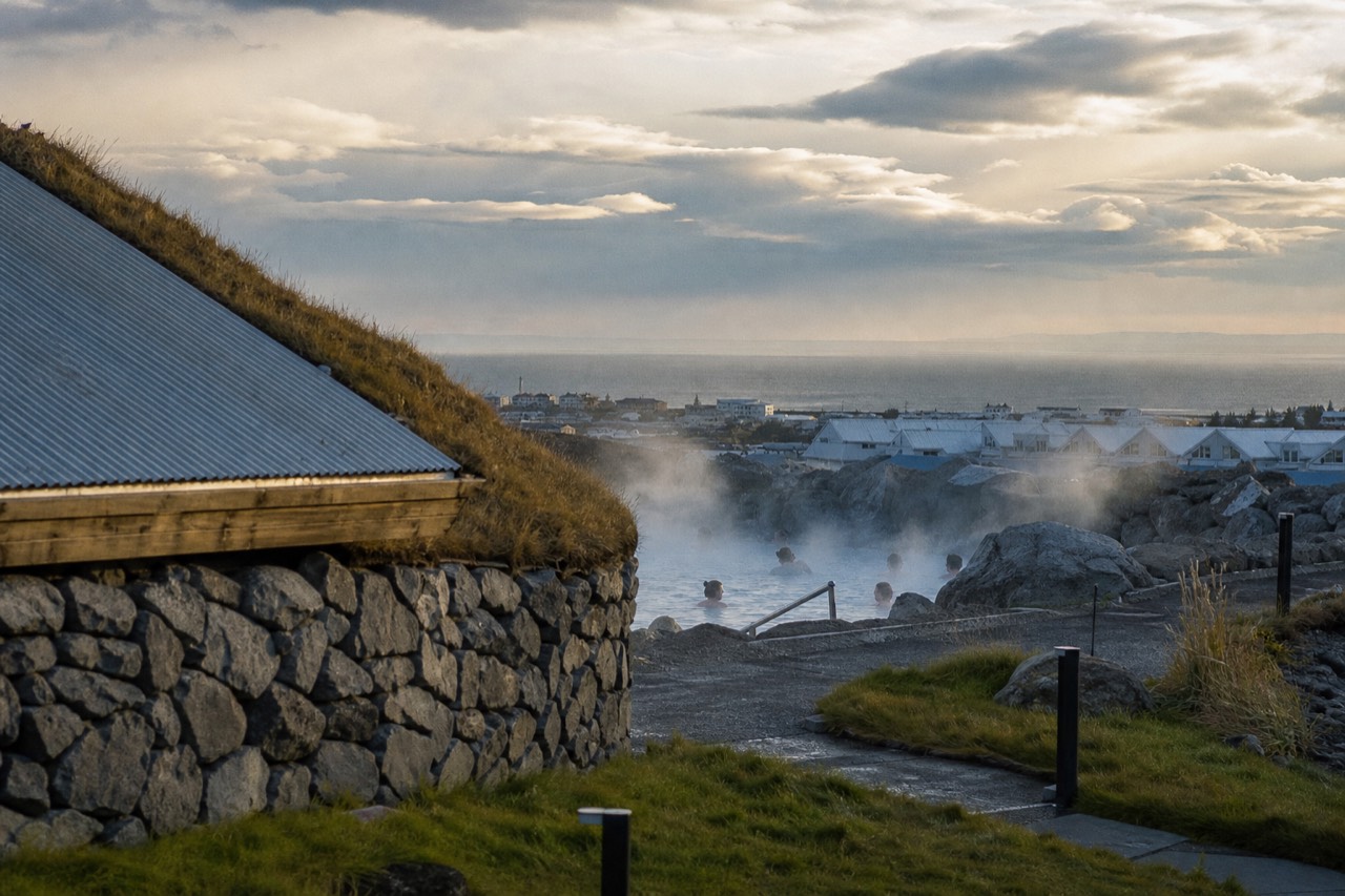 Steam rising from a geothermal lagoon at the edge of a Icelandic coastal town