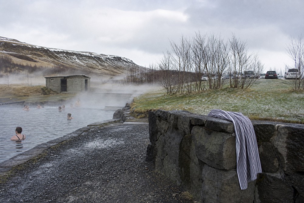 An outdoor municipal swimming pool with steam rising from hot tubs in winter