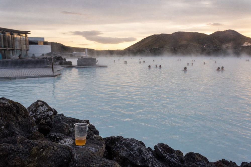 Warm geothermal water steaming against dark rocks in low evening light