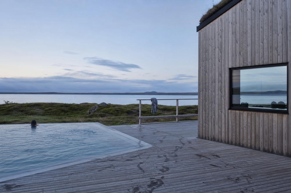 A quiet lakeside pool terrace in soft evening light